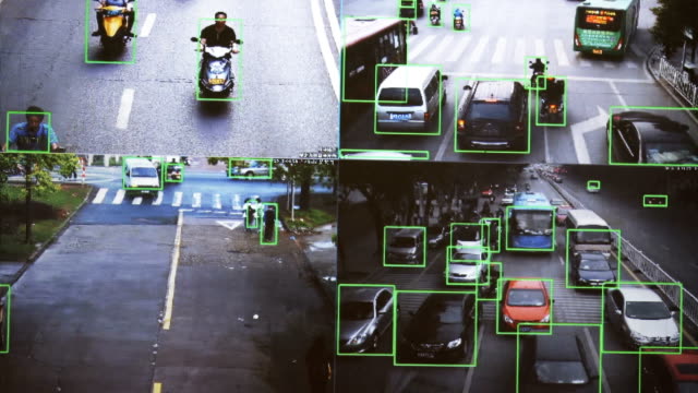 CCTV-Kamera.-Echtzeit-Verfolgung-von-Fahrzeugen-und-Menschen-auf-der-Straße.-Authentisches,-pixeliges-Bild-von-einem-realen-Monitor.