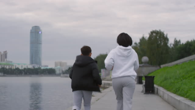 Mother-and-Son-Running-Along-Riverside-in-the-Morning