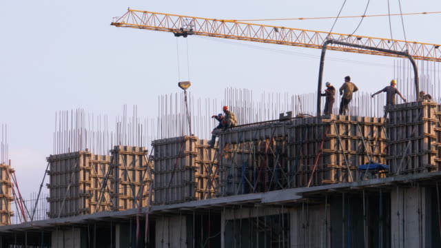 Trabajadores-en-una-obra-de-construcción.-Una-grúa-en-un-sitio-de-construcción-levanta-una-carga
