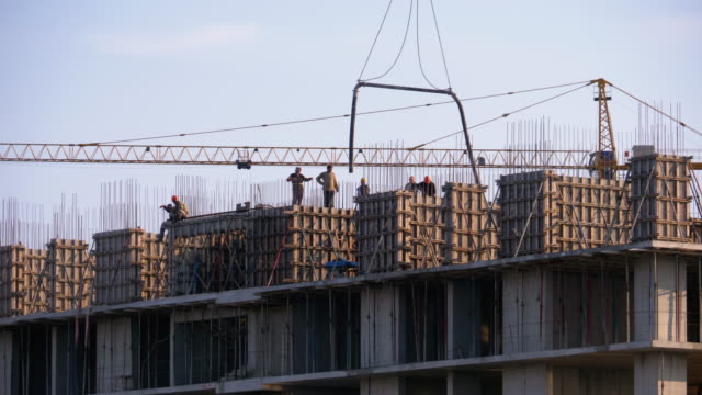 Building-Construction.-A-Crane-on-a-Construction-Site-Lifts-a-Load.-Workers-at-a-Construction-Site