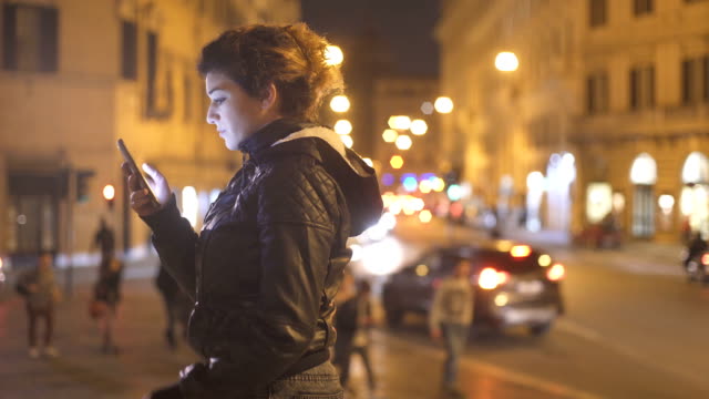 Ernste-und-besorgt-Frau-Profil-tippen-auf-das-Smartphone-in-der-Nacht-in-der-Stadt