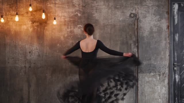 Charmante-Frau-in-einem-schwarzen-Kleid-tanzen