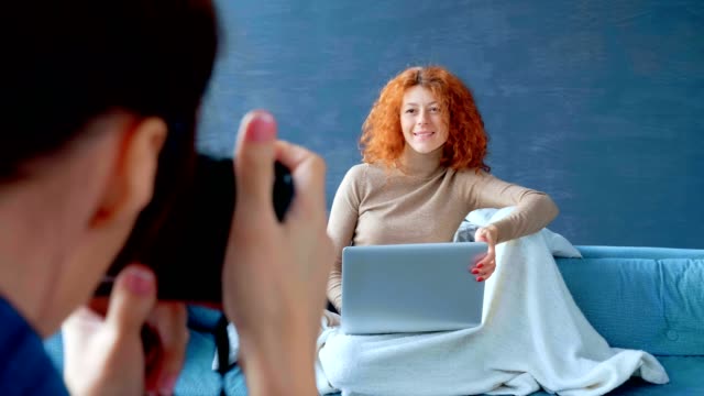 Fotografen-ein-Porträt-rothaarige-Frau-auf-einem-Laptop-arbeiten.