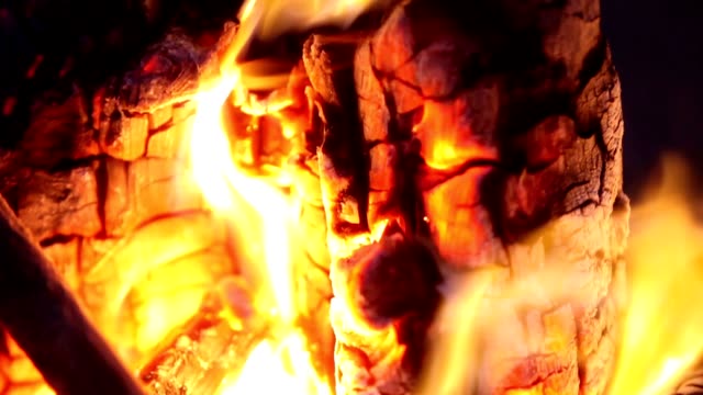 Campfire-In-The-Night.-Time-Lapse.-Burning-logs-in-orange-flames-closeup.-Background-of-the-fire.-Beautiful-fire-burns-brightly.-Embers-of-the-fire-climb-up.-Red-flames-surging-up