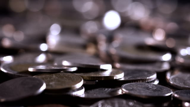 Close-up-money-coin-stacking-on--floor-in-dark-light-,-business-and-financial-for-money-saving-or-investment-background-concept--,-extremely-close-up-and-shallow-DOF