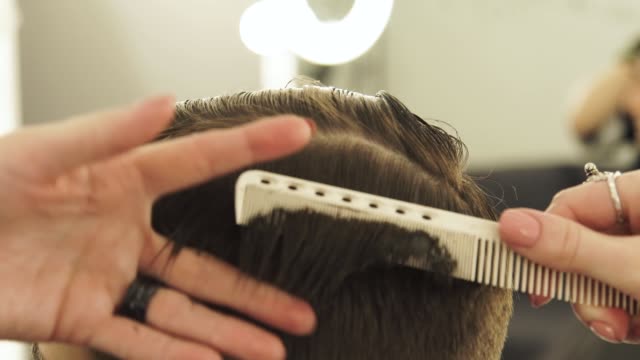 Barbier-Kämmen-Haare-und-Schneiden-mit-Friseurscheren.-Männliche-Friseure-mit-professionellen-Friseurscheren-hautnah
