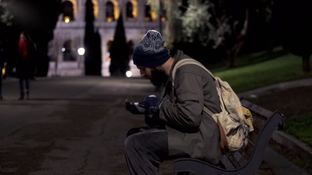 Einsamen-Bettler-auf-der-Straße-bei-Nacht---Rom-Hintergrund