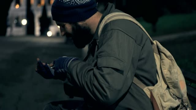 hungrige-Obdachlose-auf-Bank-nachts-seine-Münzen-zählen