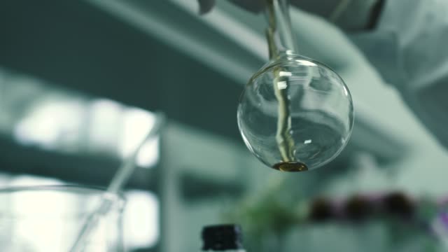 Labor-Arbeiter-gießt-die-chemische-Flüssigkeit-in-der-Flasche
