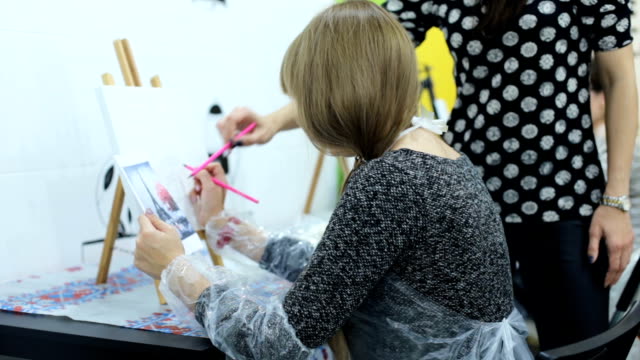 Eine-Mädchen-malt-ein-Gemälde-in-einer-Kunstschule