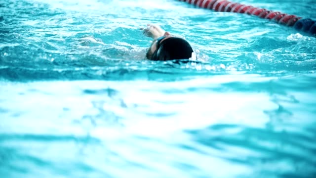 Behinderte-Mensch-schwimmt-auf-der-Rückseite-in-einem-Schwimmbad.-Slow-motion