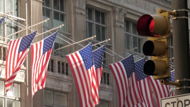 Tiro-iconic-de-la-ciudad-de-Nueva-York-con-bandera-americana,-semáforo-de-edificios