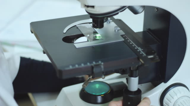 Doctor-working-with-microscope-in-laboratory.-Medical-expertise-and-diagnostic