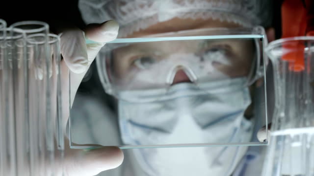 Eine-futuristische-Arzt-untersucht-ein-Chirurg-eine-technologische-digitale-holographische-Platte-menschliche-Gehirn-eine-medizinische-Maske,-eine-Kappe-braune-Augen.