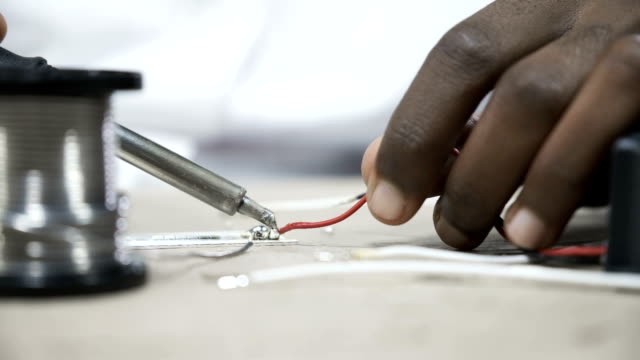 Hands-soldering-wires-at-work