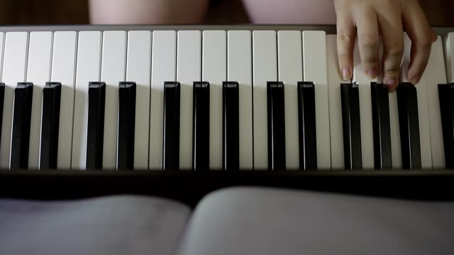 Hands-teenager-girl-playing-on-the-keyboard-of-the-digital-piano
