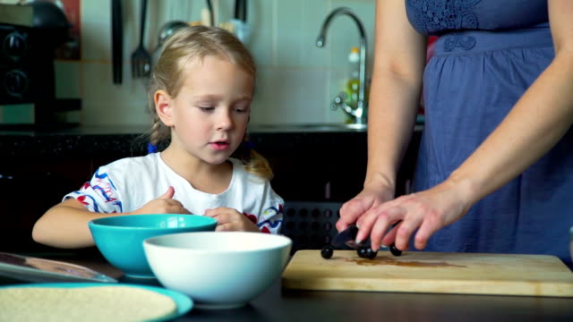 Mutter-und-Tochter-schneiden-Oliven-in-der-Küche
