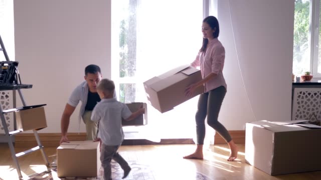 relocation-to-new-flat,-happy-family-with-small-child-boy-enjoys-new-home-after-repair-among-boxes-with-things
