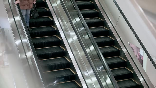 escalator-in-the-mall,-it-works.-People-ride-it,-woman-and-her-son