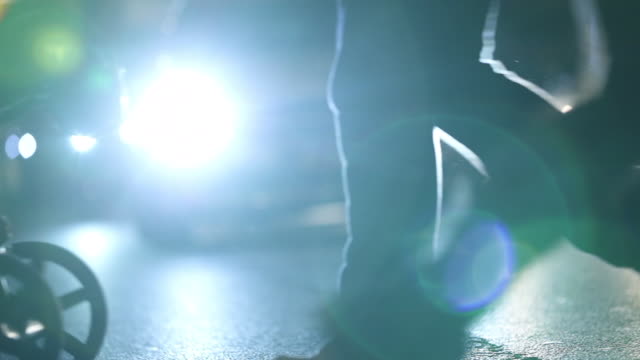 Crowd-of-Pedestrians-feet-crossing-street-at-night-with-lens-flares-hitting-camera-in-the-background