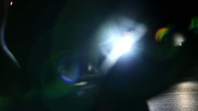 Menge-von-Fußgängern-Fuß-über-Straße-in-der-Nacht-mit-Lens-Flares-schlagen-Kamera-im-Hintergrund