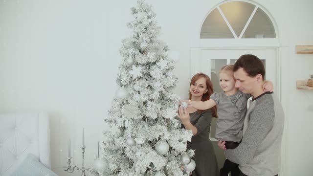 Die-Familie-steht-in-der-Nähe-der-Weihnachtsbaum,-lachen,-reden-und-Spielzeug-zu-berühren,-während-des-Wartens-auf-Weihnachten