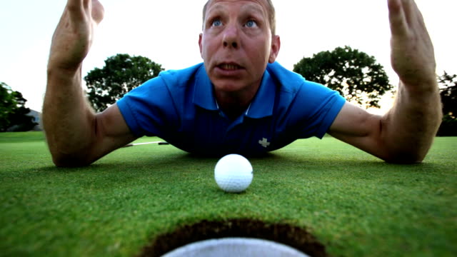 Golfista-establece-y-trata-de-soplar-su-bola-en-el-agujero.-Tiro-de-cerca.