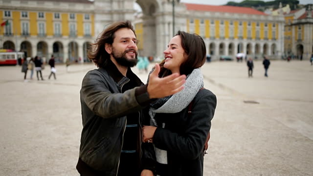 Happy-young-couple-hugging-and-looking-around-in-unknown-city.