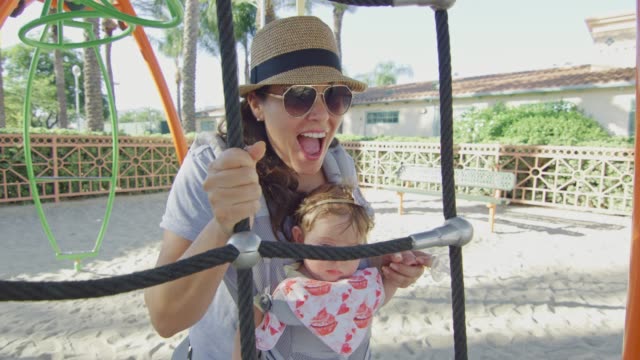 Woman-with-baby-in-carrier-having-fun-at-playground