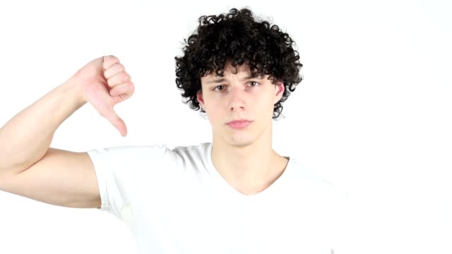 Thumbs-Down-by-Young-Man-with-Curly-Hairs,-white-Background