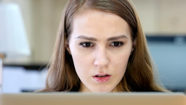Mujer-enojada-trabajando-en-ordenador-portátil-en-la-oficina