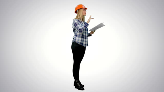 Young-engineer-woman-reading-technical-drawings-and-analyze-it-on-white-background