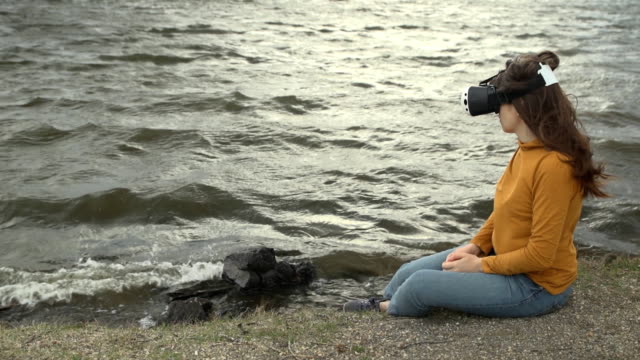 Eine-junge-Frau-nutzt-virtual-Reality-Brille-neben-starken-Wellen.