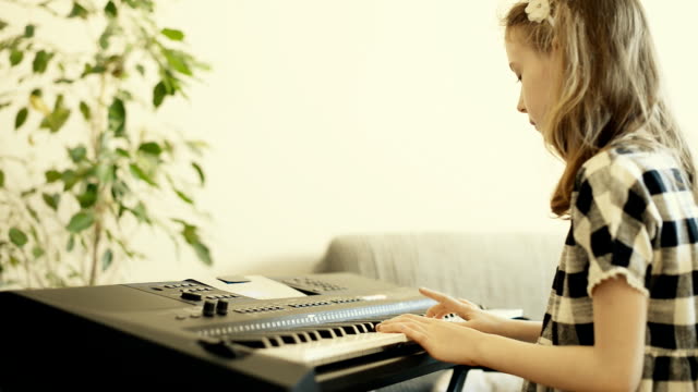 Little-girl-aprender-a-jugar-el-piano.