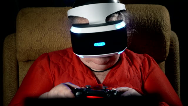 70-year-old-woman-playing-video-game-uses-VR-headset-and-gaming-controller