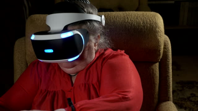 Ältere-Frau-im-VR-Kopfhörer-verwendet-Move-Motion-Controller-für-die-Videospiel-Konsole