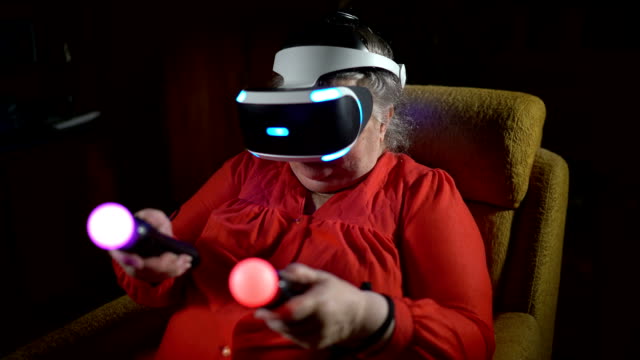 Ältere-Frau-im-VR-Kopfhörer-verwendet-Move-Motion-Controller-für-die-Videospiel-Konsole