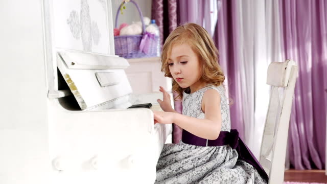 chica-juega-piano,-muchacha-en-un-vestido-con-un-cinturón-púrpura,-de-lenta