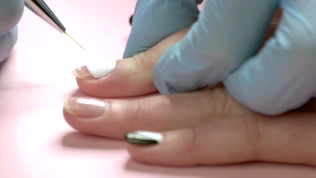 Close-up-manicure-master-drawing-on-nails.