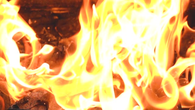 Brennenden-Flammen-des-Feuers-in-Zeitlupe-vor-dem-Hintergrund-der-Kohlen