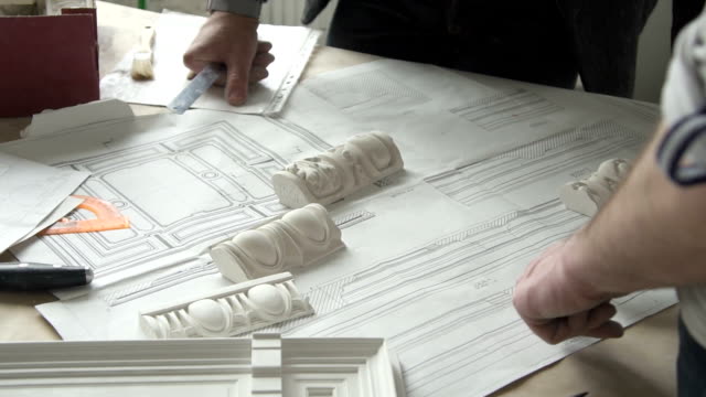 Hands-of-male-designer-putting-white-molding-samples