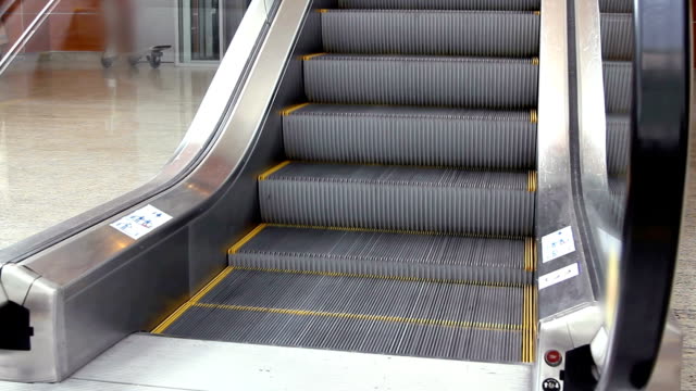 Empty-escalator-stairs-moving-up-with-logo-warning-in-modern-office-building