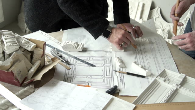 Händen-der-beiden-männlichen-Architekten-arbeiten-mit-weißem-Putz