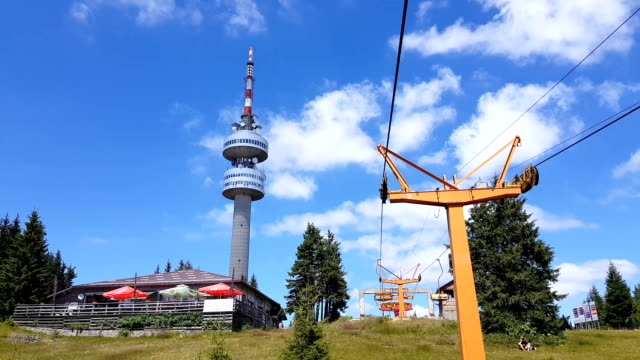 Empty-chair-lift-ascending-in-Pamporovo-winter-mountain-ski-resort-in-Bulgaria-during-summer.