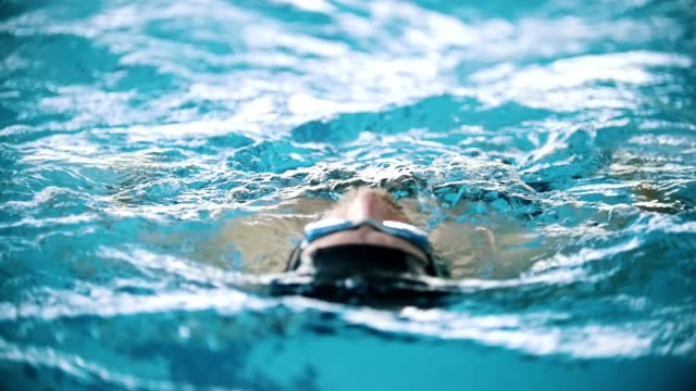Behinderte-Mensch-schwimmt-auf-der-Rückseite-in-einem-Schwimmbad-in-Richtung-der-Kamera.-Nächster-Nähe-erschossen.-Slow-motion