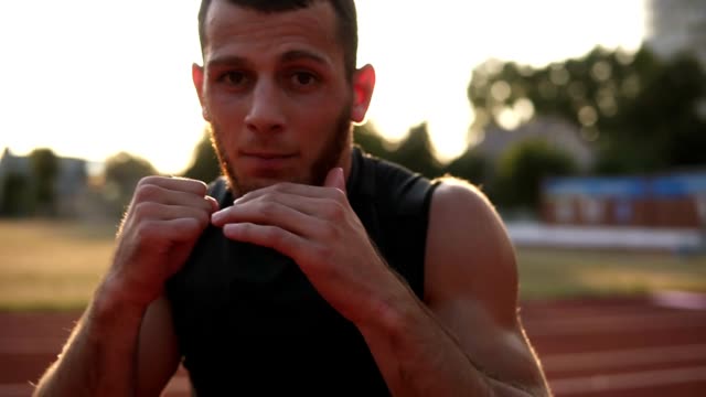 Accelerated-handhelded-footage-of-a-young-boxer-exercising-outdoors.-Portrait-of-a-man-boxing-with-invisible-opponent,-punching.-Front-view