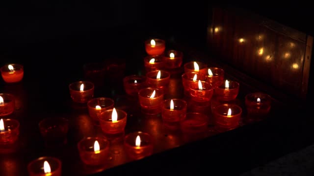Rote-Kerzen-in-der-Dunkelheit-in-der-Kirche-in-Europa