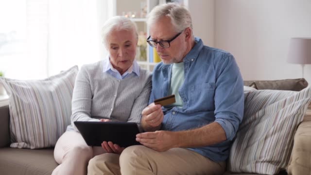 happy-senior-couple-with-tablet-pc-and-credit-card
