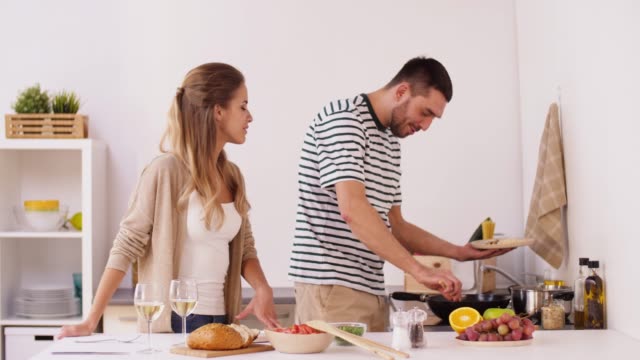 happy-couple-cooking-and-serving-food-at-home