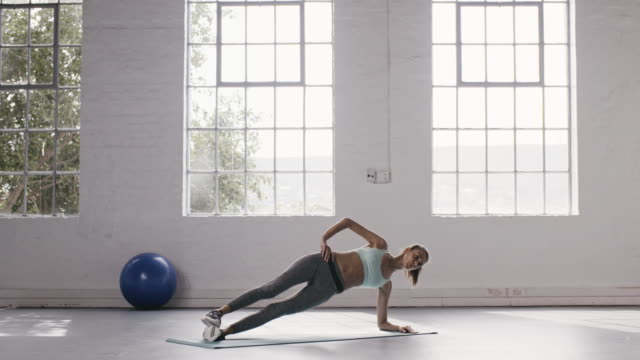 Frau-tut-Seite-Planken-Workout-im-Fitness-studio
